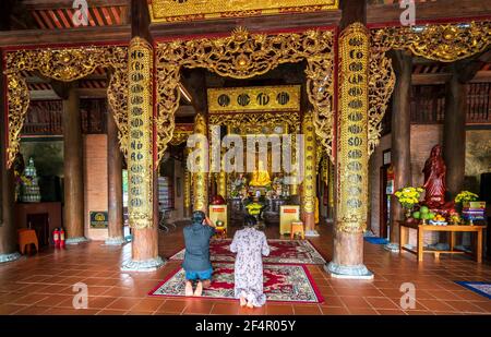 Couple praying for family peace in Ho Quoc temple on the morning of the full moon day on the beautiful island of Phu Quoc, Vietnam Stock Photo