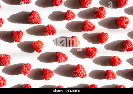 Pattern of fresh raspberry with shadow on light background. Flat lay. Stock Photo