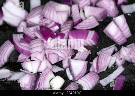 Chopped red onion on a black teflon background Stock Photo
