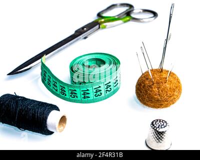 Measuring meter and sewing accessories on a white background. Yardstick. Centimeter or Inch. Needles and threads. Tailors scissors. Seamstress tool. C Stock Photo