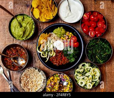 Top view of bowls of various delicious Mexican food on the wooden surface Stock Photo