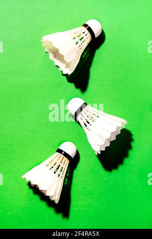 Summer activity cocept, shuttlecocks for badminton game on green noisy background with hard light and shadows Stock Photo
