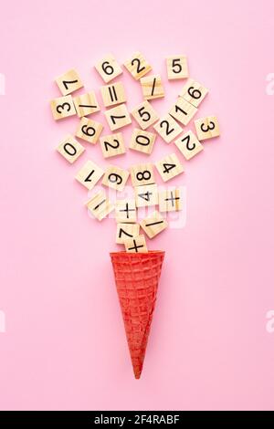 Wooden plaques with numbers and signs in an ice cream cone on a color background Stock Photo