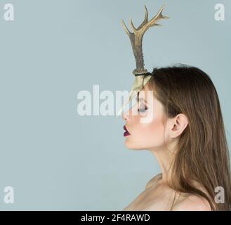 Young woman shaman conjures, she has a horn of an animal on her head. Stock Photo