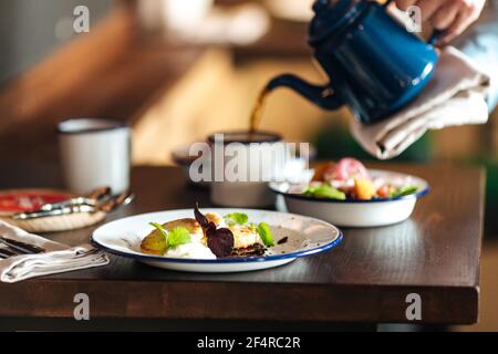 Pouring coffee and having breakfast in the cafe Stock Photo