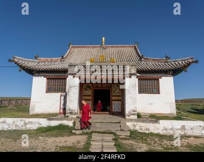 Shankh, Mongolia - August 29, 2019: Temple of the Shankh Monastery with two monks and dog in front of the temple during summer with blue sky. Stock Photo