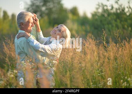 Happy senior couple dancing in summer park Stock Photo