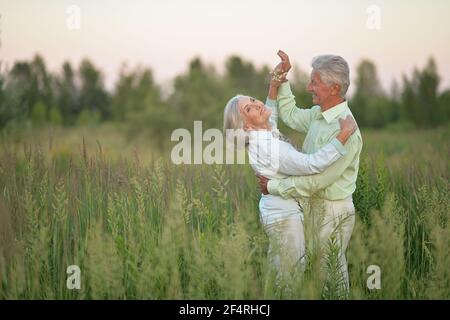 Happy senior couple dancing in summer park Stock Photo