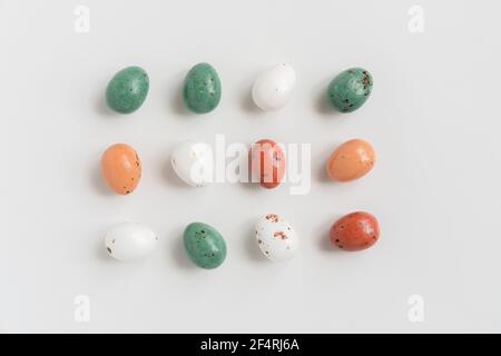 Easter minimal composition with multicolored eggs on the white background. Easter concept. Copy space, flat lay. Stock Photo