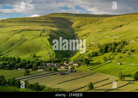 Scenic Dales village (houses) nestling in valley by dry-stone walls, hillside slopes & steep-sided Cam Gill gorge - Starbotton, Yorkshire England, UK.
