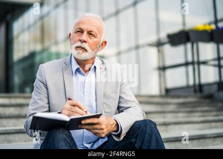 Senior businessman is pensive. He is thinking about his schedule. Stock Photo