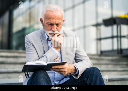 Senior businessman is pensive. He is thinking about his schedule. Stock Photo
