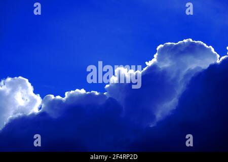 Silver lined cumulus cloud against deep blue sky Stock Photo