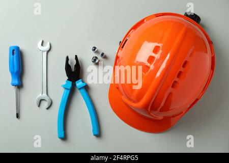 Hard hat and working tools on light gray background Stock Photo