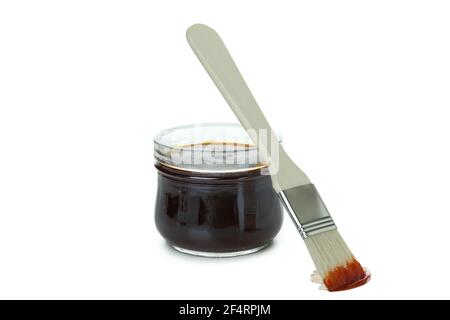 Glass jar of barbecue sauce with brush isolated on white background Stock Photo
