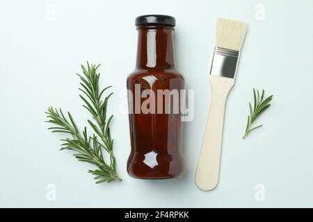Barbecue sauce, rosemary and brush on white background Stock Photo