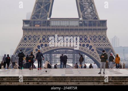 Paris, France - Janauary 31, 2021 : Tourists and parisians in front of the Eiffel Tower in Paris during covid restrictions. Stock Photo