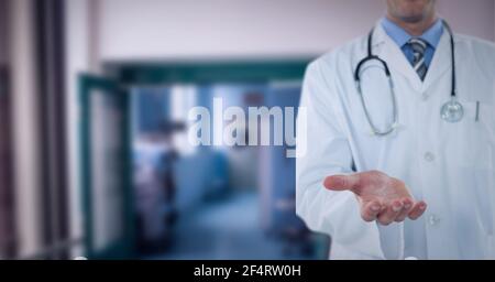 Mid section of male doctor with cupped han standing at hospital Stock Photo