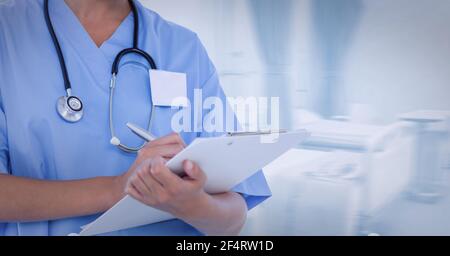 Mid section of female health worker writing on clipboard at hospital Stock Photo
