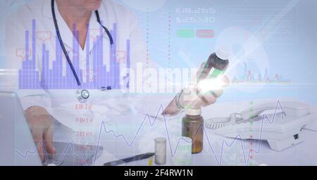Financial data processing against mid section of female doctor holding medicine Stock Photo