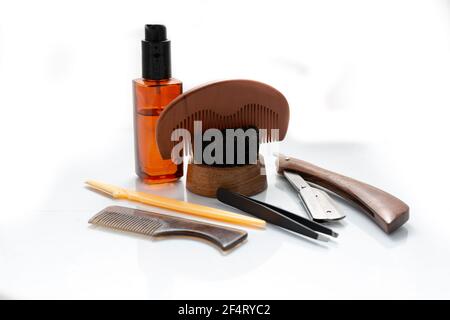 A selection of men's beard grooming products that include oil, cut throat razor and a brush, shot against a clean white background Stock Photo