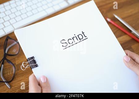 Female hands holding script over table closeup Stock Photo