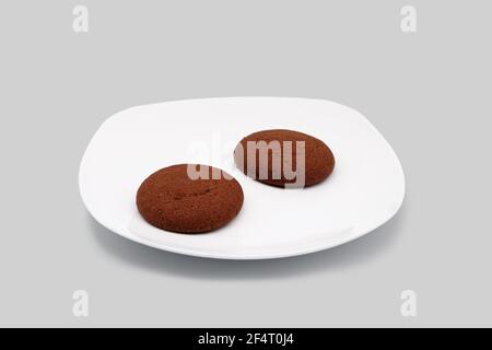 Oatmeal cookies on a white plate. Close-up. Isolated on a gray background. Stock Photo