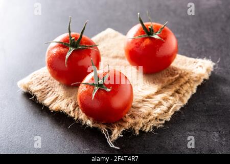 Fresh tomatoes on black slate background Stock Photo