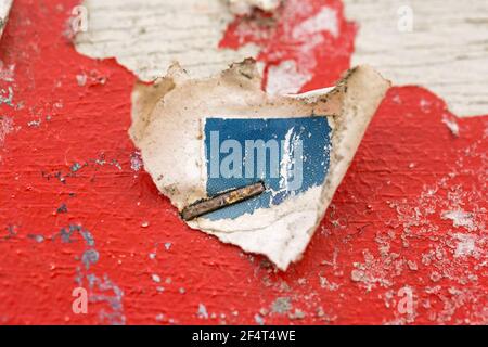Abstract background macro shot of a red painted poster board with metal staples embedded in it. Stock Photo