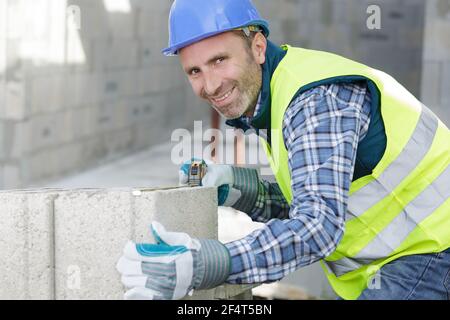 bricklayer builder working with autoclaved aerated concrete blocks Stock Photo
