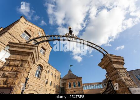 The ornate wrought iron John Smiths sign over the entrance to the John Smiths brewery in Tadcaster, North Yorkshire Stock Photo