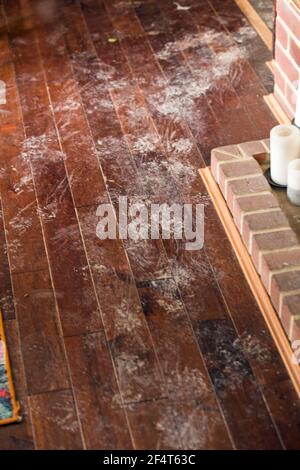 A pet dog has left muddy paw prints all over a wood floor Stock Photo