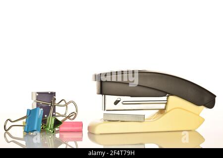 One stationery stapler and several binders on a white background. Stock Photo