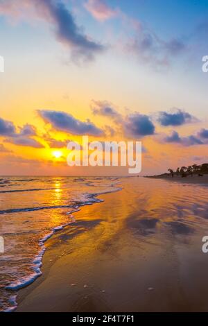 sunset landscape photo of Kuakata sea beach . evening sky reflected on wet sand . Stock Photo