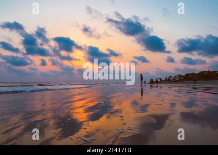 sunset landscape photo of Kuakata sea beach . evening sky reflected on wet sand . Stock Photo