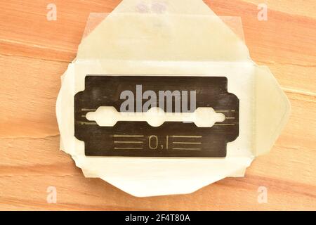 Shaving blade, macro, on a wooden table. Stock Photo