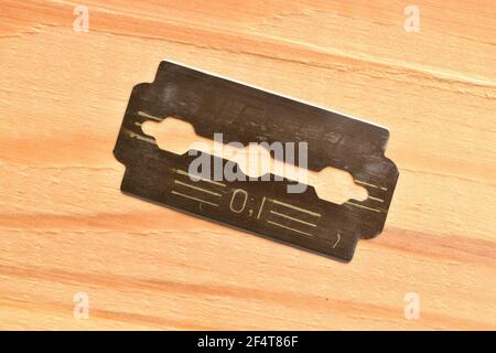 Shaving blade, macro, on a wooden table. Stock Photo