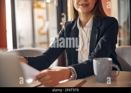 Smiling dark-haired female designer working in her office Stock Photo