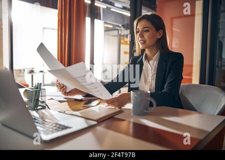 Concentrated female designer analyzing the building plans Stock Photo