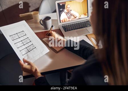 Long-haired female engineer working at a new floor plan Stock Photo