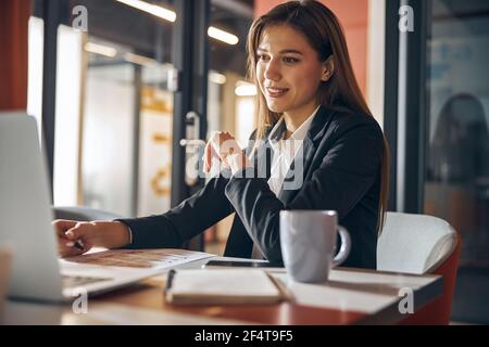 Draftswoman sitting at the desk with technical drawings on it Stock Photo