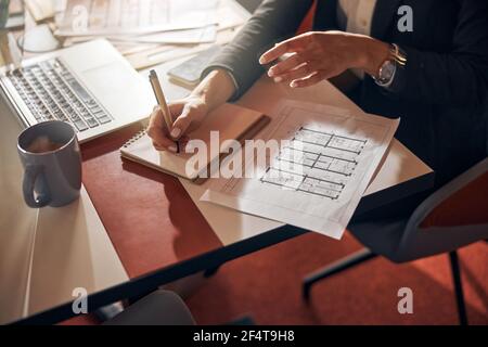 Woman taking notes with a ball-point pen at the office desk Stock Photo