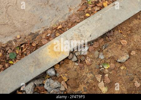 poorly executed road repairs. replacing the old curb stone with a new one Stock Photo