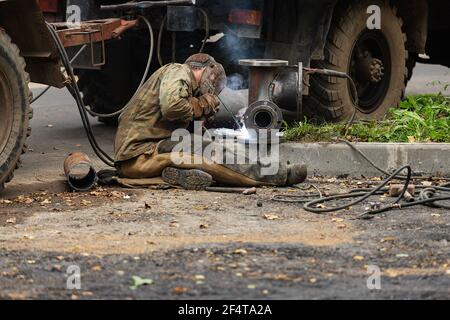 poorly executed road repairs. replacing the old curb stone with a new one Stock Photo