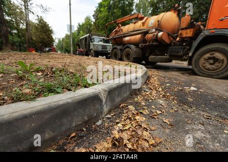 poorly executed road repairs. replacing the old curb stone with a new one Stock Photo