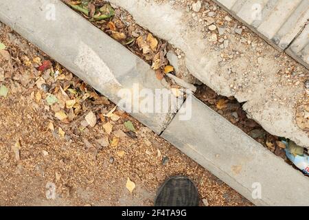 poorly executed road repairs. replacing the old curb stone with a new one Stock Photo