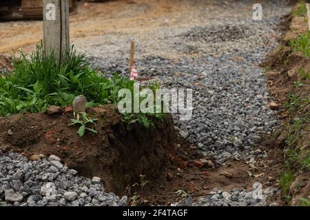 poorly executed road repairs. replacing the old curb stone with a new one Stock Photo
