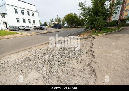poorly executed road repairs. replacing the old curb stone with a new one Stock Photo