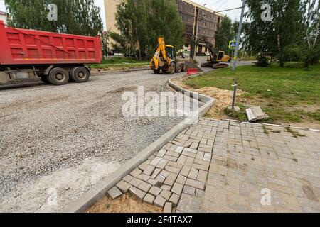 poorly executed road repairs. replacing the old curb stone with a new one Stock Photo