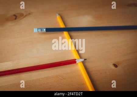 Pencils on table in the colours yellow, red and blue. Can be used to write, draw, erase and more creative outlets. Stock Photo